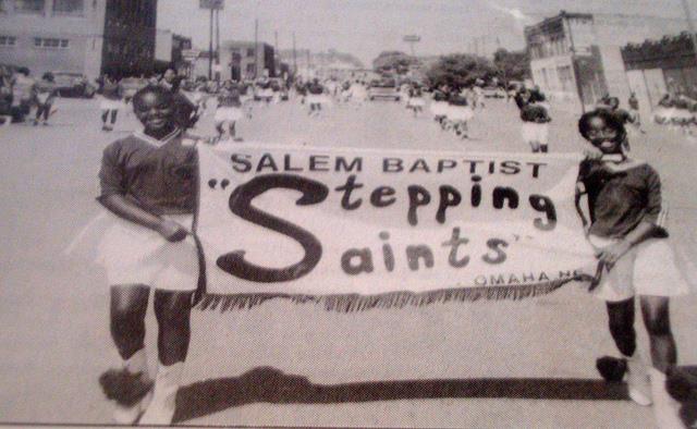 Two younger girls marching with a Salem Baptist Stepping Saints banner